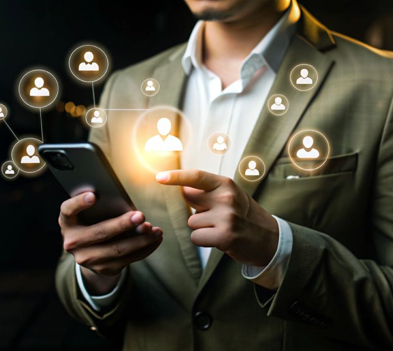 Businessperson in a suit using a smartphone with glowing network icons representing connections and networking.