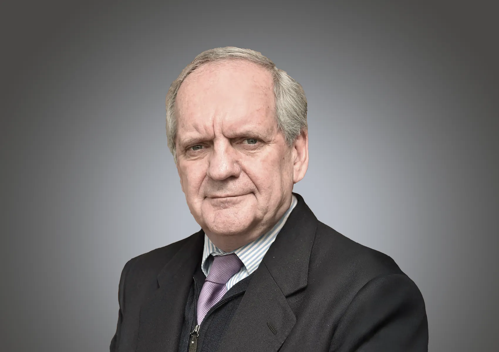 Professional head-and-shoulders portrait of an older man in a dark suit and striped shirt against a gray gradient background.
